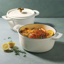 White enameled Dutch oven with lid and roasted chicken inside