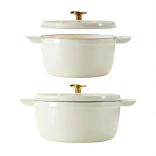 Two white enameled cast iron round Dutch ovens with gold knob lids and matching handles