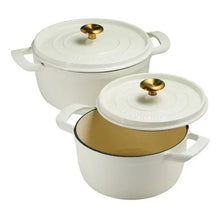 Two white enameled Dutch ovens with gold knobs and handles