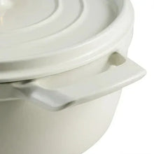 White enameled Dutch oven lid edge with side handle loop and embossed detailing