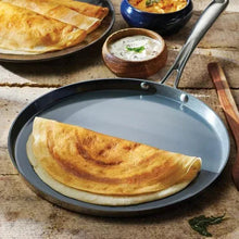 Dosa tawa with folded crepe on a flat cooking surface