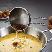 Stainless ladle pouring into a large pot with simmering curry