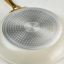 Cream fry pan interior with dotted ceramic surface and center logo