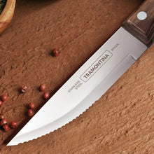Stainless steak knife with dark wood handle and engraved blade