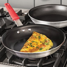 10 in nonstick fry pan with red handle cooking omelet on gas burner