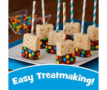 Marshmallow treat cubes on a tray with colorful candy-coated pieces and striped straws