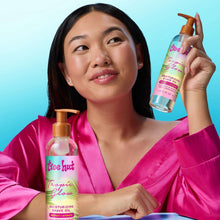 Moisturizing shave oil bottle with orange pump held near a person in a pink robe