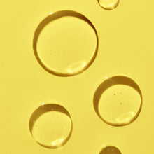 Golden shave oil droplets and small pools on a smooth surface