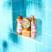 Moisturizing shave oil bottle with orange pump displayed with matching body care items