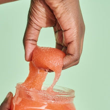 Tree Hut Bikini Reef sugar scrub scoop held in hand over open jar