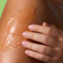 Hand smoothing Pink Hibiscus body scrub on skin, glossy exfoliated texture
