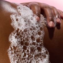 Foaming gel wash on skin with bubbles, hand holding lather