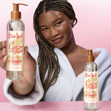 Tree Hut Coco Colada moisturizing shave oil pump bottles held by a person
