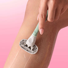 Pink Hibiscus shave oil applied to leg with razor and pump nozzle
