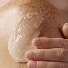 Body skin with cream scrub and sugar granules, hand gently rubbing