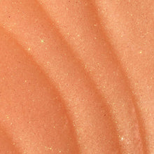 Close-up of orange sugar scrub granules on skin