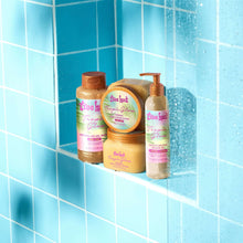 Tree Hut Tropic Glow bath products set on shower ledge, golden beige jars and bottles