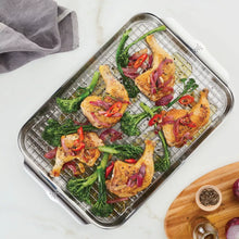 Wire roasting rack tray holding seasoned vegetables and chicken pieces