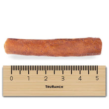 Collagen bully roll dog chew, single brown roll beside ruler for size