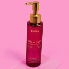 TRULY luxury shave oil bottle with gold pump and Unicorn Fruit label, deep magenta