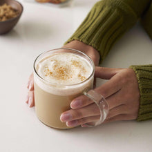 Creamy latte in clear glass mug with cinnamon foam top
