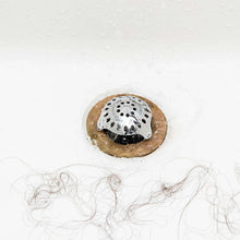 Tub drain strainer with stainless mesh and black base over hair