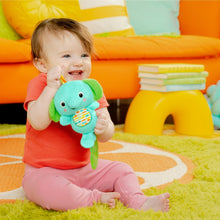 Baby holding teal elephant clip-on plush toy with green ears and fabric page