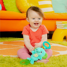 Baby sitting with teal elephant clip-on plush toy featuring fabric activity panel