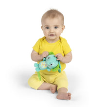 Baby holding teal elephant clip-on plush with green ears and fabric activity panel