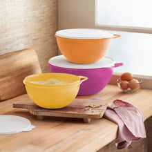 Yellow and orange Thatsa bowls with a purple bowl behind on a board