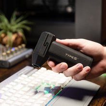 Black Type S electric air duster held above a computer keyboard