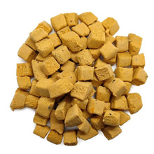 Pile of freeze-dried salmon pet treat cubes, golden-yellow
