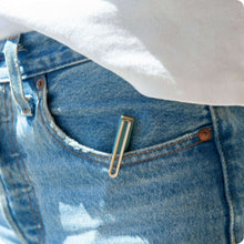 Felt tip pen clipped in denim pocket; close-up of gold-barreled pen