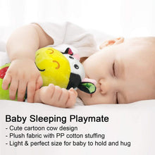 Sleeping baby playmate plush cow with green textured attachment on a white blanket