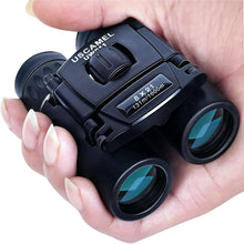 USCAMEL black binoculars with folding design, held in hands with two eyepieces visible.