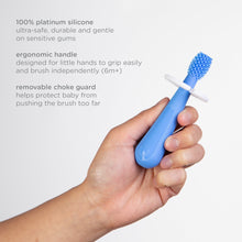Blue silicone finger toothbrush with removable guard held in a hand