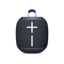 Dark gray wireless Bluetooth speaker with blue handle and white cross logo on front.