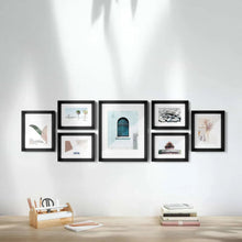 7-piece photo frame set with dark frames, arranged in a gallery wall layout