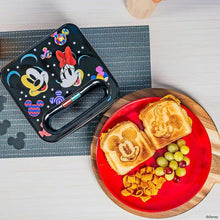 Mickey and Minnie sandwich maker with colorful top, next to toasted sandwiches
