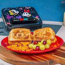 Mickey and Minnie sandwich maker with colorful top, beside toasted sandwich shapes