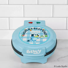 Light blue Bluey waffle maker with “World’s Best Chef” lid graphic and indicator buttons
