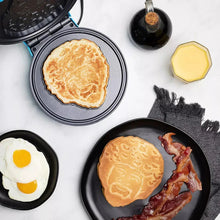 Blue waffle maker with open plates, showing two cooked waffles