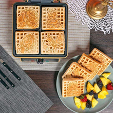 Closed waffle maker with four character waffle molds, plus sliced waffles on plate