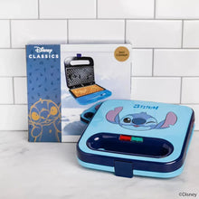 Stitch-themed blue waffle maker with dark handle, closed lid and open plates