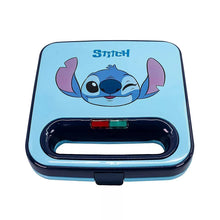Blue Stitch waffle maker with dark lid and handle, open cooking plates