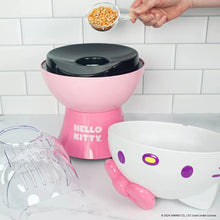 Pink Hello Kitty popcorn maker with black warming top and white serving scoop
