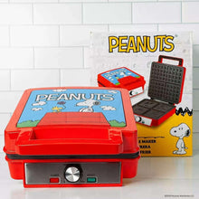 Red Peanuts-themed waffle maker with open lid and grid plates
