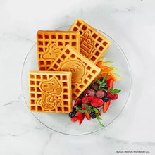 Golden square character waffles on a plate with strawberries and greens