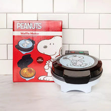 Snoopy waffle maker next to red Peanuts waffle maker box on a kitchen counter