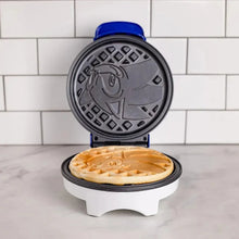 Blue round Sonic waffle maker with patterned lid open and waffles inside